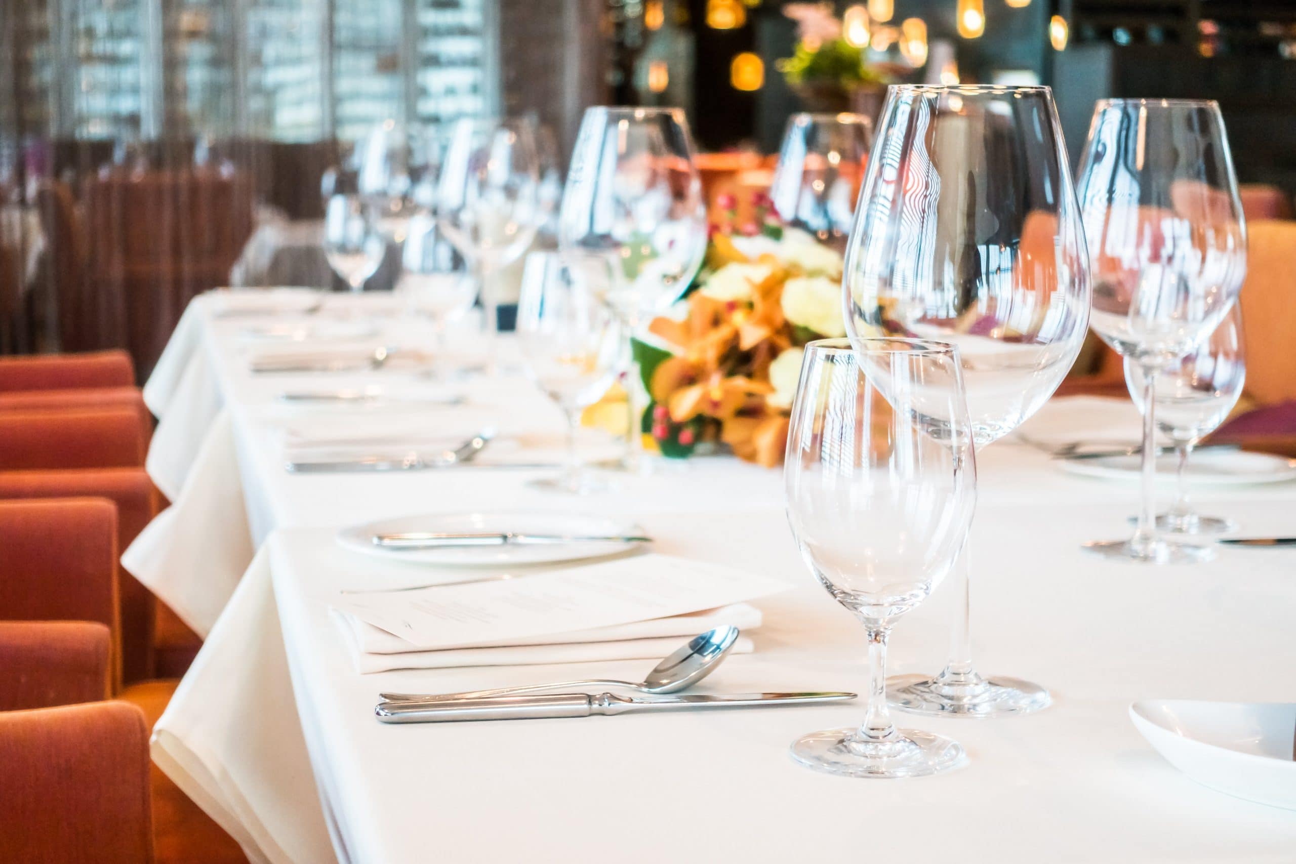 Soirée, diner pour déguster des produits originaux et locaux Table avec verres à vin, couvert, fleurs.