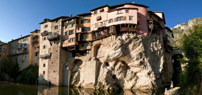 Maisons aux façades colorées suspendues sur une roche au dessus de l'eau à Pont en Royans